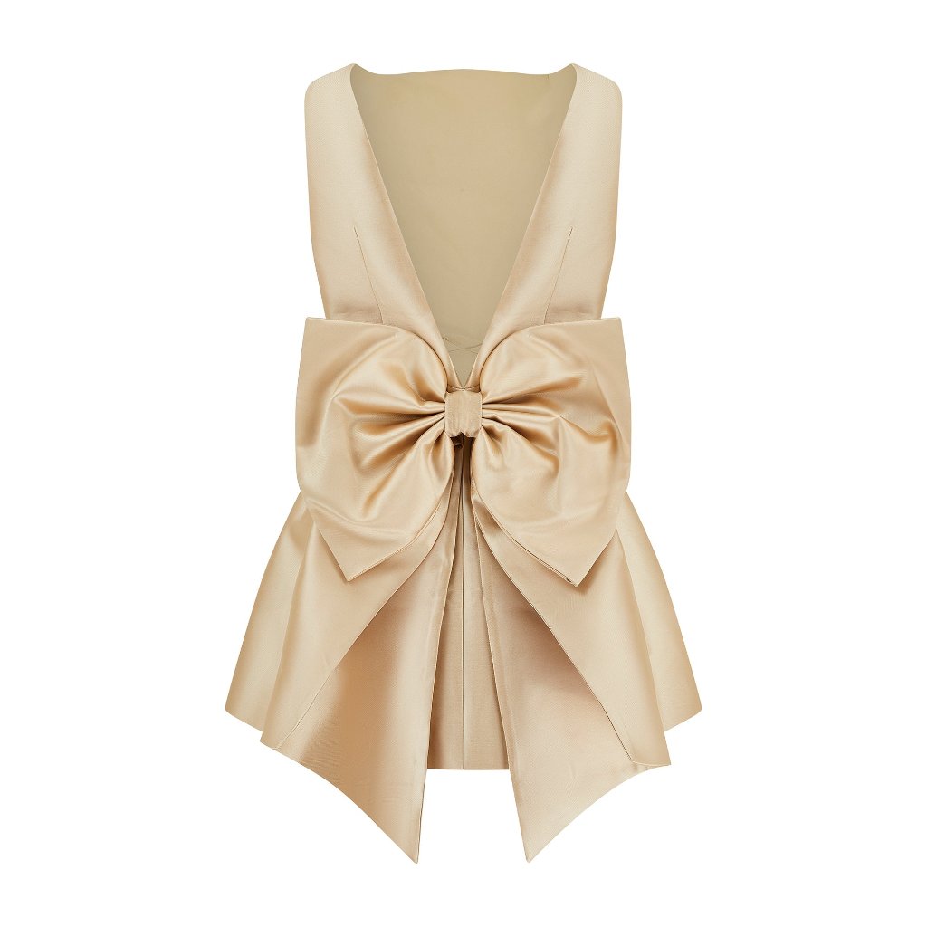 The Ultimate Muse Bow Detail Mini by The Wedding Wardrobe, available in size 12, is an elegant beige satin sleeveless top accented with a statement bow at the front. It features a deep V neckline and a flared hem.